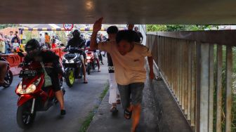 Pengendara motor melintas di Jembatan Antelope, Curug, Bekasi, Jawa Barat, Selasa (14/6/2022). [Suara.com/Alfian Winanto]