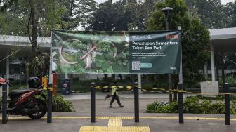 Petugas kebersihan berjalan di Tebet Eco Park, Jakarta, Rabu (15/6/2022). ANTARA FOTO/Aprillio Akbar

