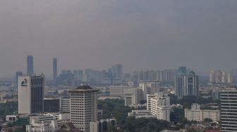 Kabut polusi udara menyelimuti gedung-gedung bertingkat di Jakarta, Rabu (15/6/2022). [Suara.com/Alfian Winanto]