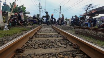 Pengendara motor melintas di perlintasan sebidang Kereta Api (KA) liar di Jalan Paseban, Bojong Gede, Kabupaten Bogor, Jawa Barat, Kamis (16/6/2022).  ANTARA FOTO/Yulius Satria Wijaya