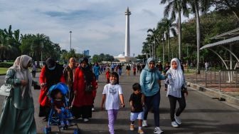 Warga berwisata mengunjungi Monumen Nasional (Monas) di Gambir, Jakarta Pusat, Kamis (16/6/2022). [Suara.com/Alfian Winanto]