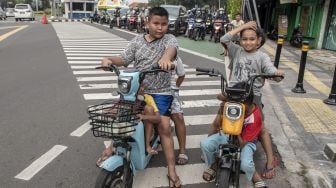 Sejumlah bocah mengendarai motor listrik di jalan raya di Jakarta, Kamis (16/6/2022).  ANTARA FOTO/Muhammad Adimaj