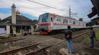 
Warga menjaga perlintasan sebidang Kereta Api (KA) liar di Jalan Paseban, Bojong Gede, Kabupaten Bogor, Jawa Barat, Kamis (16/6/2022).  ANTARA FOTO/Yulius Satria Wijaya