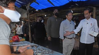 Presiden Joko Widodo (kanan) berbincang dengan pedagang ikan saat mengunjungi Pasar Tradisional di Baros, Serang, Banten, Jumat (17/6/2022). [ANTARA FOTO/Asep Fathulrahman/ foc]
