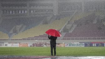 Perangkat pertandingan mengecek kondisi lapangan saat turun hujan pada pertandingan PSIS Semarang melawan Dewa United FC grup A Piala Presiden 2022 di Stadion Manahan, Solo, Jawa Tengah, Jumat (17/6/2022). [ANTARA FOTO/Mohammad Ayudha/wsj]