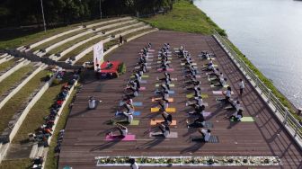 Foto udara warga melakukan gerakan yoga di Pulau Wangi Pantai Boom, Banyuwangi, Jawa Timur, Minggu (19/6/2022).  ANTARA FOTO/Budi Candra Setya