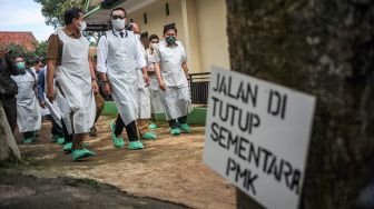 Gubernur Jawa Barat Ridwan Kamil (kedua kiri) berjalan untuk meninjau vaksinasi penyakit mulut dan kuku (PMK) hewan ternak sapi perah di Cilembu, Kabupaten Sumedang, Jawa Barat, Senin (20/6/2022). ANTARA FOTO/Raisan Al Farisi
