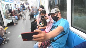 Penumpang berswafoto di atas atas MRT di Jakarta, Rabu (22/6/2022). ANTARA FOTO/Akbar Nugroho Gumay
