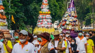 Peserta pawai budaya berjalan mengitari kawasan Taman Lapangan Banteng, Jakarta Pusat, Rabu (22/6/2022). [Suara.com/Alfian Winanto]