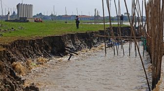 Perangkat desa melihat kondisi abrasi yang terjadi di bibir pantai desa Dadap, Juntinyuat, Indramayu, Jawa Barat, Kamis (23/6/2022). ANTARA FOTO/Dedhez Anggara