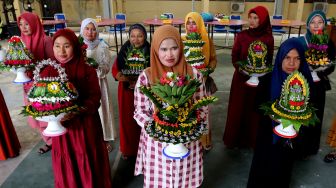 Peserta memperlihatkan daun sirih yang telah ditata saat mengikuti lomba merangkai sirih yang diselenggarakan Polresta Banda Aceh dalam rangka menyambut HUT Ke-76 Bhayangkara di Banda Aceh, Aceh, Jumat (24/6/2022).ANTARA FOTO/Irwansyah Putra
