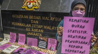 Sejumlah pengunjuk rasa yang tergabung di Koalisi Buruh Migran Berdaulat (KBMB) melakukan aksi di depan Kedutaan Besar Malaysia, Jakarta, Jumat (24/6/2022). ANTARA FOTO/Galih Pradipta