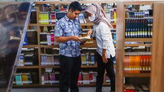 Pengunjung membaca buku di Perpustakaan Umum Daerah Provinsi DKI Jakarta, Taman Ismail Marzuki, Cikini, Jakarta Pusat, Kamis (30/6/2022). [Suara.com/Alfian Winanto]