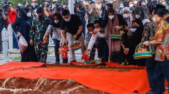 Keluarga menabur bunga ke dalam pusara Menteri Pendayagunaan Aparatur Negara dan Reformasi Birokrasi (Menpan RB) Tjahjo Kumolo saat prosesi pemakaman di Taman Makam Pahlawan, Kalibata, Jakarta Selatan, Jumat (1/7/2022). [Suara.com/Alfian Winanto]