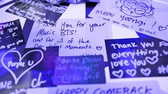 Catatan dari para penggemar K-pop ditempel di dinding saat mereka mengunjungi toko pop-up BTS yang dibuat untuk mempromosikan album 'Proof' di Los Angeles, California, Amerika Serikat, Rabu (15/6/2022). [Patrick T. FALLON/AFP]