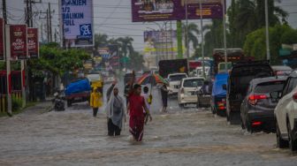 Sejumlah relawan mengatur arus lalu lintas di jalan nasional Ahmad Yani yang terendam banjir di Kecamatan Landasan Ulin, Banjarbaru, Kalimantan Selatan, Senin (4/7/2022). [ANTARA FOTO/Bayu Pratama S/aww]