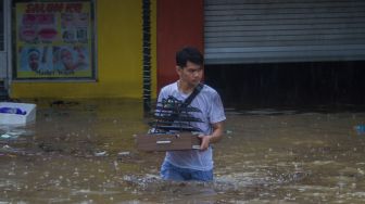 Warga membawa benda berharganya saat banjir merendam kawasan permukiman di Kecamatan Landasan Ulin, Banjarbaru, Kalimantan Selatan, Senin (4/7/2022). [ANTARA FOTO/Bayu Pratama S/aww]