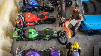 Petugas mendata barang bukti berupa motor sport dari kasus penipuan investasi opsi biner di Kejaksaan Negeri Kabupaten Bandung, Jawa Barat, Selasa (5/7/2022). [ANTARA FOTO/Raisan Al Farisi/foc]