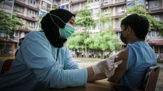 Petugas menyuntikkan vaksin COVID-19 dosis ketiga kepada warga di RPTRA Rusun Benhil, Jakarta, Rabu (6/7/2022). ANTARA FOTO/Rivan Awal Lingga