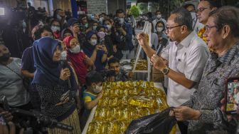 Menteri Perdagangan Zulkifli Hasan (kedua kanan) berdialog dengan warga yang akan membeli minyak goreng kemasan saat peluncuran minyak goreng kemasan rakyat (MinyaKita) di kantor Kementerian Perdagangan, Jakarta, Rabu (6/7/2022). ANTARA FOTO/Galih Pradipta
