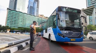 Petugas gabungan yang terdiri dari Ditlantas Polda Metro Jaya dan Dinas Perhubungan (Dishub) DKI Jakarta mengatur arus lalu lintas di kawasan Bundaran Hotel Indonesia (HI) , Jakarta Pusat, Rabu (6/7/2022). [Suara.com/Alfian Winanto]