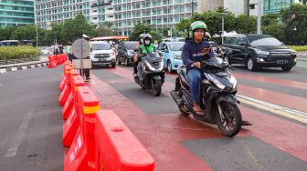 Petugas gabungan yang terdiri dari Ditlantas Polda Metro Jaya dan Dinas Perhubungan (Dishub) DKI Jakarta mengatur arus lalu lintas di kawasan Bundaran Hotel Indonesia (HI) , Jakarta Pusat, Rabu (6/7/2022). [Suara.com/Alfian Winanto]