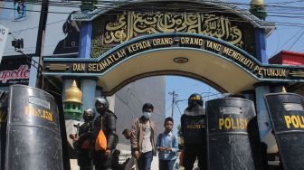 Polisi berjaga di depan gerbang Pondok Pesantren Shiddiqiyyah Ploso saat proses upaya penangkapan Moch Subchi Azal Tsani (MSAT) di Jombang, Jawa Timur, Kamis (7/7/2022).  ANTARA FOTO/Syaiful Arif
