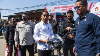 Presiden Joko Widodo (tengah) menyapa warga saat meninjau proyek penataan Kampung Belawan Bahari di Belawan, Kota Medan, Sumatera Utara, Kamis (7/7/2022). [ANTARA FOTO/Fransisco Carolio/Lmo/hp]
