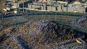 Gambar udara memperlihatkan jamaah haji berkumpul di puncak Gunung Arafah atau Jabal Rahmah saat melaksanakan ibadah wukuf di Arafah, tenggara kota suci Makkah, Jumat (8/7/2022). [AFP]
