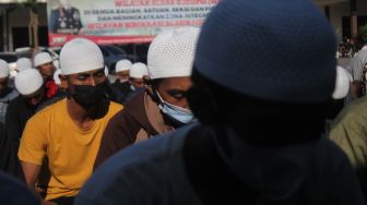 Simpatisan yang diamankan saat upaya jemput paksa Moch Subchi Azal Tsani (MSAT) di Pondok Pesantren (Ponpes) Shiddiqiyah berdoa bersama sebelum dipulangkan dari Mapolres Jombang, Jawa Timur, Jumat (8/7/2022). [ANTARA FOTO/Syaiful Arif/aww]