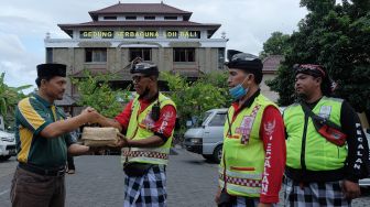 Panitia kurban dari Lembaga Dakwah Islam Indonesia (LDII) Provinsi Bali memberikan daging kurban kepada warga Bali saat tradisi Ngejot pada Hari Raya Idul Adha 1443 Hijriah di Denpasar, Bali, Minggu (10/7/2022).  ANTARA FOTO/Nyoman Hendra Wibowo