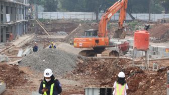 Pekerja beraktivitas di proyek revitalisasi Taman Mini Indonesia Indah (TMII), Jakarta Timur, Selasa (12/7/2022). [Suara.com/Alfian Winanto]
