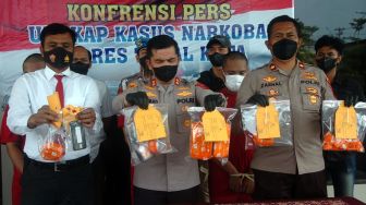 Kapolres Tegal Kota AKBP Rahmad Hidayat (tengah) didampingi Wakapolres Tegal Kota Kompol Zaenal Arifin (kanan) dan Kasat Narkoba AKP Slamet Sugiarto (kiri) menunjukkan barang bukti narkoba dan tersangka saat ungkap kasus di Polres Tegal Kota, Jawa Tengah, Selasa (12/7/2022). ANTARA FOTO/Oky Lukmansyah