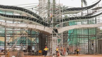 Pekerja beraktivitas di proyek revitalisasi Taman Mini Indonesia Indah (TMII), Jakarta Timur, Selasa (12/7/2022). [Suara.com/Alfian Winanto]
