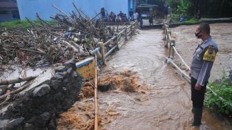 Seorang petugas melihat sampah yang menyumbat Sungai Dawe di Desa Golantepus, Mejobo, Kudus, Jawa Tengah, Kamis (14/7/2022). ANTARA FOTO/Yusuf Nugroho

