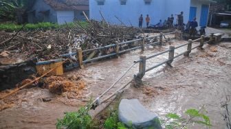 Warga berdiri di depan balai desa yang terdampak banjir di Desa Golantepus, Mejobo, Kudus, Jawa Tengah, Kamis (14/7/2022). ANTARA FOTO/Yusuf Nugroho