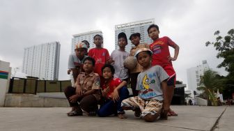 Anak-anak berpose usai bermain bola di Trotoar Taman Ismail Marzuki, Kamis, Jakarta (14/7).  [Suara.com/Oke Atmaja]
