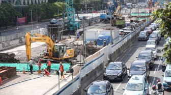 Pekerja menyelesaikan proyek Moda Raya Terpadu (MRT) Fase II di Jalan MH Thamrin, Jakarta Pusat, Kamis (14/7/2022). [Suara.com/Alfian Winanto]