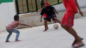 Anak-anak bermain bola di Trotoar Taman Ismail Marzuki, Kamis, Jakarta (14/7).  [Suara.com/Oke Atmaja]
