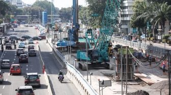 Pekerja menyelesaikan proyek Moda Raya Terpadu (MRT) Fase II di Jalan MH Thamrin, Jakarta Pusat, Kamis (14/7/2022). [Suara.com/Alfian Winanto]