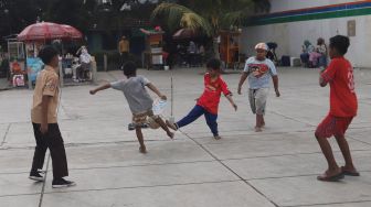 Anak-anak bermain bola di Trotoar Taman Ismail Marzuki, Kamis, Jakarta (14/7).  [Suara.com/Oke Atmaja]
