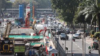 Pekerja menyelesaikan proyek Moda Raya Terpadu (MRT) Fase II di Jalan MH Thamrin, Jakarta Pusat, Kamis (14/7/2022). [Suara.com/Alfian Winanto]