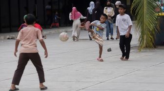 Anak-anak bermain bola di Trotoar Taman Ismail Marzuki, Kamis, Jakarta (14/7).  [Suara.com/Oke Atmaja]
