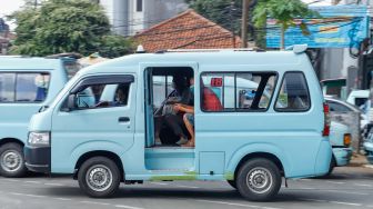 Angkutan Umum yang membawa penumpang melintas di Jalan Raya Jatinegara Barat, Jakarta Timur, Jumat (15/7/2022). [Suara.com/Alfian Winanto]