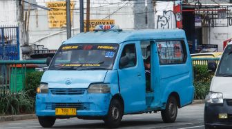 Angkutan Umum yang membawa penumpang melintas di Jalan Raya Jatinegara Barat, Jakarta Timur, Jumat (15/7/2022). [Suara.com/Alfian Winanto]