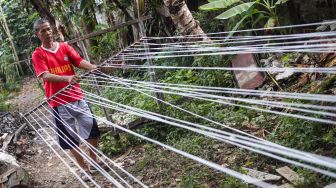 Pekerja melakukan proses pemintalan benang di Kawasan Kebayoran, Jakarta Selatan, Jumat (15/7/2022). [Suara.com/Alfian Winanto]