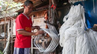 Pekerja melakukan proses pemintalan benang di Kawasan Kebayoran, Jakarta Selatan, Jumat (15/7/2022). [Suara.com/Alfian Winanto]