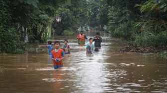 Sejumlah warga berjalan saat banjir di Villa Pamulang, Pondok Petir, Depok, Jawa Barat, Sabtu (16/7/2022). ANTARA FOTO/Asprilla Dwi Adha
