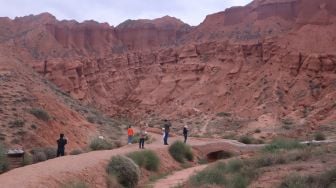 Wisatawan berswafoto di area objek wisata bukit warna-warni Taman Bumi Nasional Ashgang di Kabupaten Guide, Provinsi Qinghai, China, Kamis (14/7/2022). ANTARA FOTO/M. Irfan Ilmie
