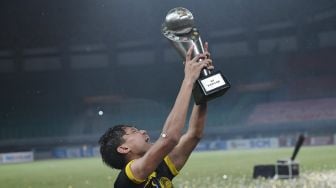 Pesepak bola Tim Nasional Malaysia U-19 Muhammad Faiz Amer Runnizar berselebrasi mengangkat piala usai mengalahkan Tim Nasional Laos U-19 dalam babak final Piala AFF U-19 2022 di Stadion Patriot Candrabhaga, Bekasi, Jawa Barat, Jumat (15/7/2022). [Antara Foto]

